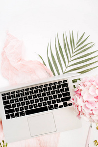 带有笔记本电脑的女性家庭办公桌粉红色绣球花束粉彩毯Monstera叶板和白色背景上的配件。平躺，俯视工作区。