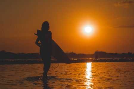 穿着冲浪板站在海里的女人