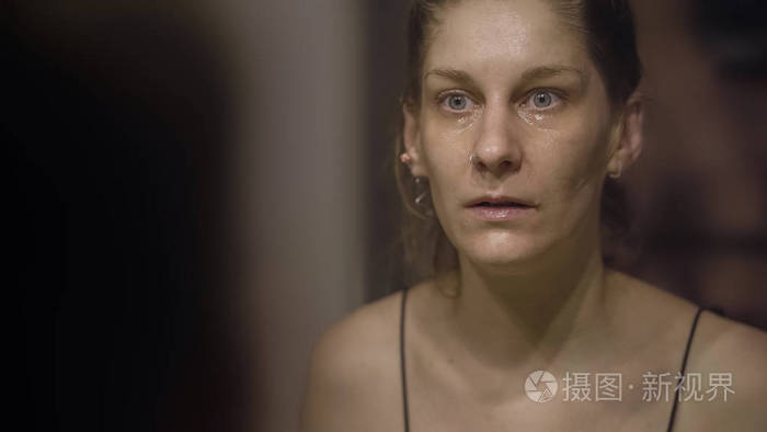 哭泣的女人看着镜子里的自己