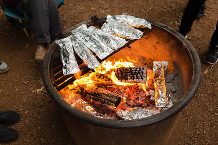 在篝火旁用箔纸烹制的野营餐