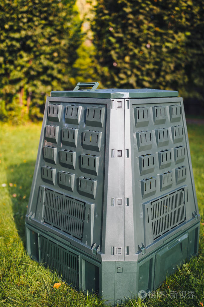 绿草和树叶背景的堆肥箱