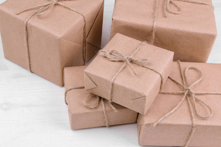 用手工纸包裹在白色木桌上的盒子. 邮件或投递概念照片