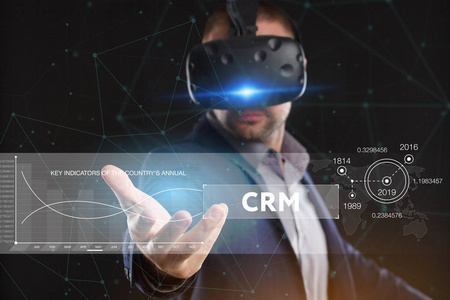 商业技术互联网和网络概念。 在虚拟现实眼镜中工作的年轻商人看到了铭文CRM