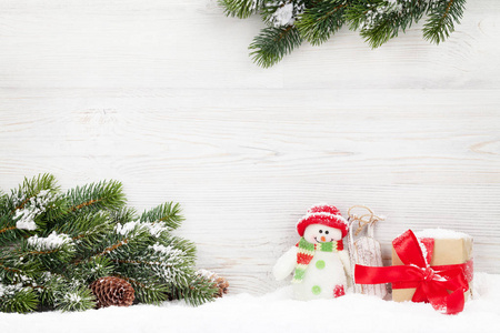 圣诞雪人玩具礼盒和杉树枝。 圣诞贺卡有你问候的空间