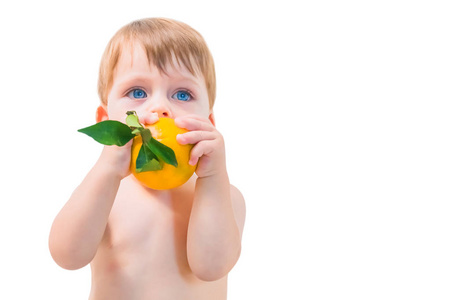 蓝眼睛金发男孩在白色背景上拿着一个橘子。 孤立的