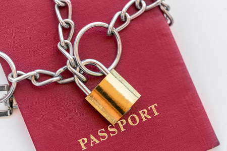 红色护照包裹在一条链子上，白色背景上有金色的锁