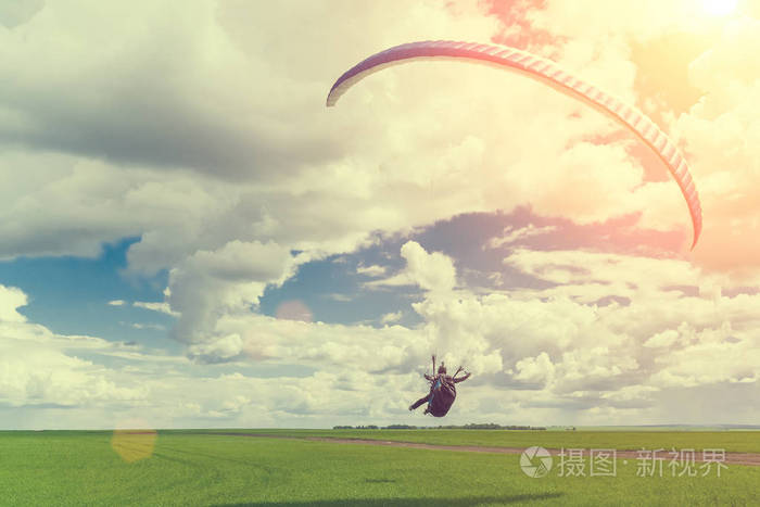 在阳光下起飞时乘坐滑翔伞的人