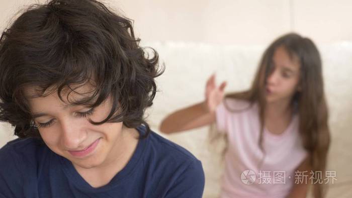 青少年双胞胎兄妹吵架坐在沙发上特写