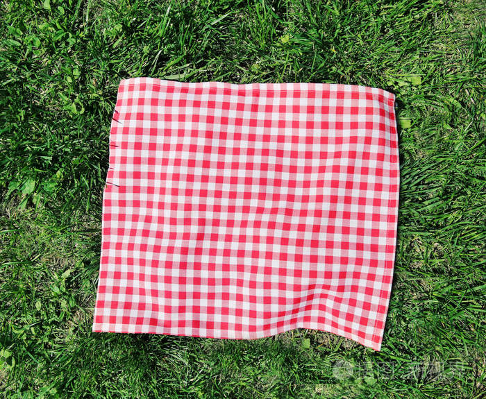 红色格子野餐布在绿色的草地上俯视