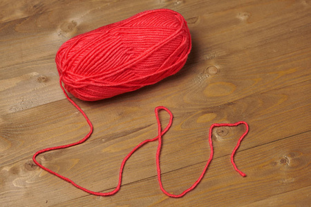 用毛线在木制背景上编织的红球