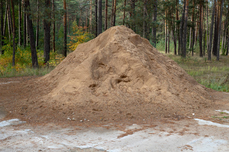 混凝土广场上的一堆沙子.材料组成中建筑商的材料计数.秋天的季节.