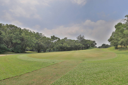 多云的绿色高尔夫球场球道照片