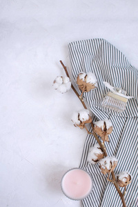 秋季成分干棉枝蜡烛香水瓶上皱褶条纹餐巾白色背景。 简单和柔软。 顶部视图复制空间。