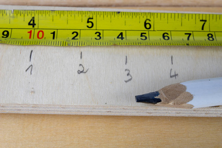 s measure and pencil on a workshop table. Measurement of materia