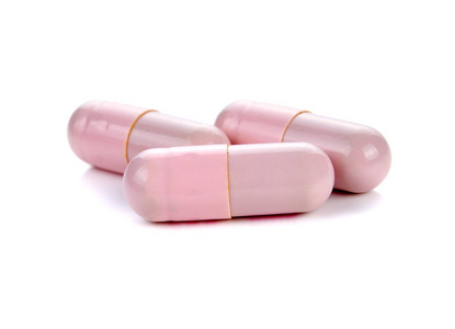 白色背景上的粉红色药丸胶囊