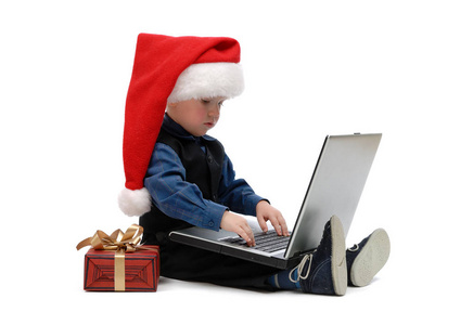 戴着圣诞帽的小男孩，白色背景的笔记本电脑被隔离了