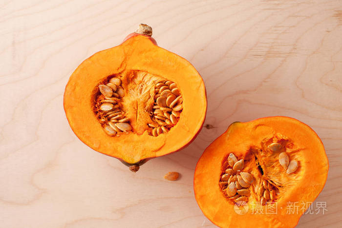 在木光背景上用种子切成半个南瓜. 复制空格文本.