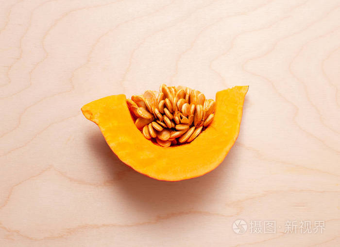 在木光背景上用种子切成半个南瓜复制空格文本