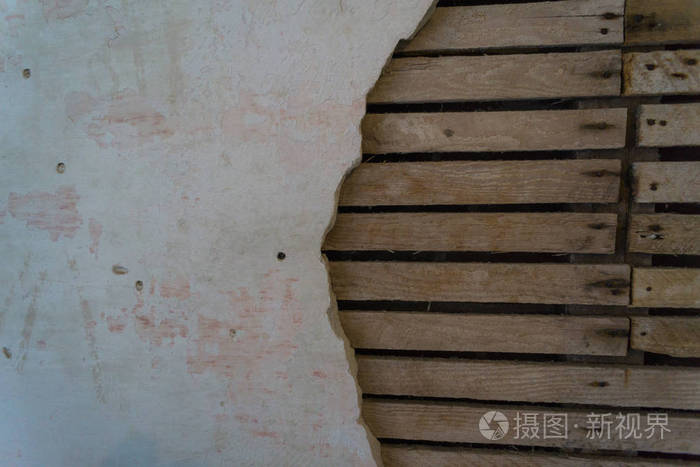 破损的墙壁有破损的干墙和暴露的板条和下面的木材