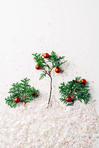 平躺着，松树的树枝上装饰着圣诞球，白色的表面上闪烁着闪光