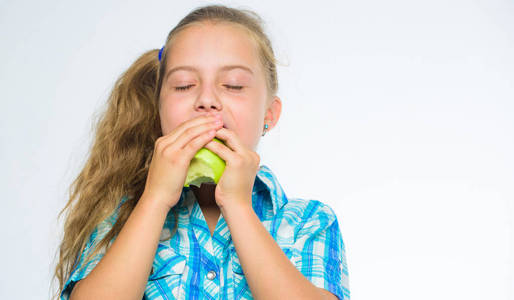 找出你身体需要的维他命和矿物质。小女孩吃绿色苹果果。苹果的营养维生素含量。维生素营养概念。良好的营养是健康的必要条件。