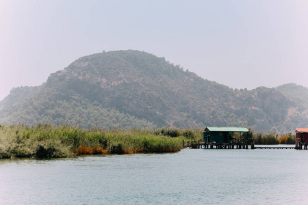 阿兹马克河阿克亚卡穆格拉土耳其。 自然构成。 夏季背景。 带湖的乡村景观。 船在阿兹马克河上航行。 人们正在阿克亚卡村的阿兹马克