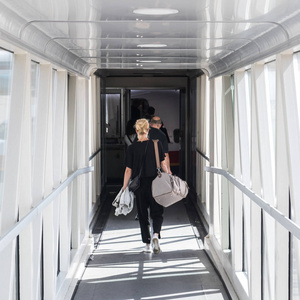 携带手提行李袋的女乘客, 步行飞机登机走廊