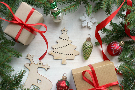 新的一年是2019年。带有圣诞树树枝和圣诞装饰品的圣诞木制背景。白色木制背景上的圣诞礼物，冷杉树枝和玩具..