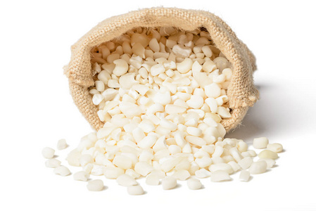 白色玉米粒在白色背景上分离的麻袋中照片