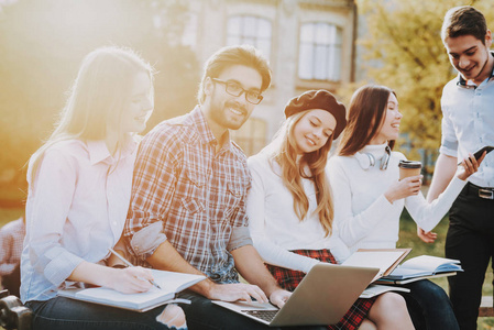 一群年轻人. 坐下. 自由职业者. 嬉皮士. 知识. 建筑. 庭院. 大学.