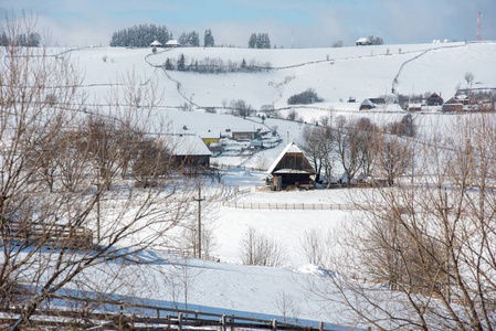 冬季乡村景观，积雪覆盖树木和山丘