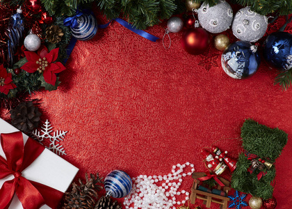 美丽的装饰品圣诞假日抽象背景玩具和红色礼品与树球装饰在红色背景平躺。 布局与自由文本空间。