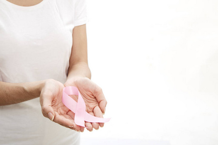 女人手拿粉红色乳腺癌意识丝带。 医疗保健和医学概念。
