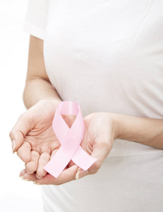 女人手拿粉红色乳腺癌意识丝带。 医疗保健和医学概念。