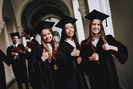 竖起大拇指。 女孩。 好心情。 大学。 快乐。 帽子。 建筑。 幸福。 情报。 文凭。 站着。 走廊。 大学。 长袍。 毕业。 