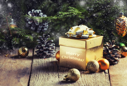 圣诞或新年黄金礼品盒，节日装饰和圣诞球背景下的绿色云杉选择性焦点。