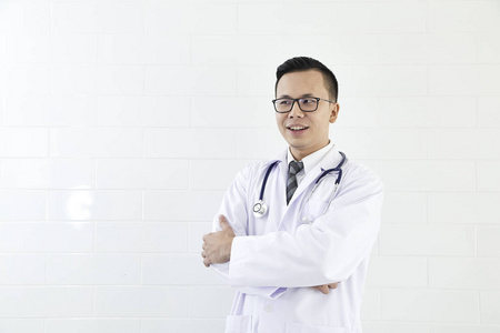 亚洲男医生微笑着，手臂交叉在胸部肖像概念的技术交流。 复制空间。