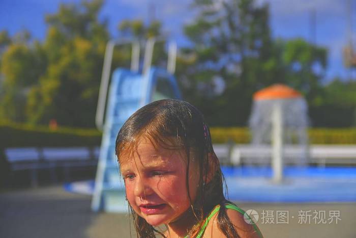 快乐的小女孩在游泳池里享受夏日. 可爱的女孩冻得发抖.