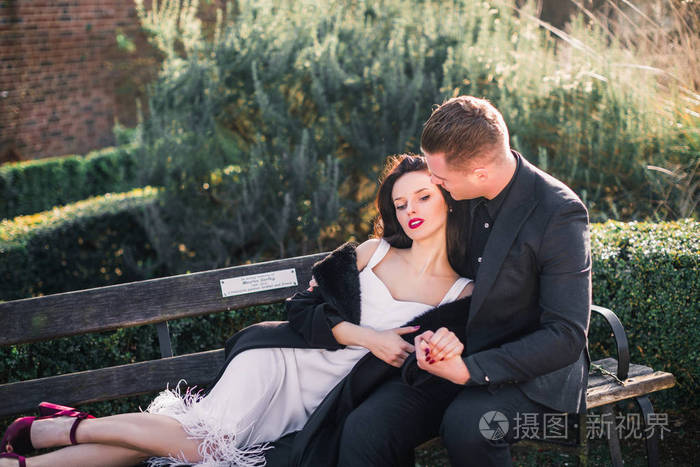 令人惊奇的一对相爱的夫妇一个女人躺在长凳上一个
