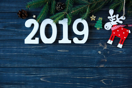 白色木制数字2019与装饰分支云杉在灰色木制桌子。 新年和圣诞节装饰概念