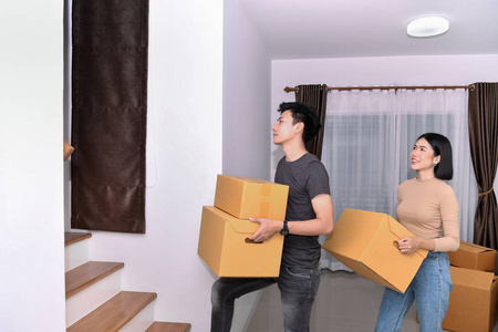 年轻的亚洲女人把她们的东西放在一个纸箱里.
