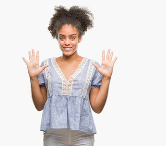 年轻的非洲美国妇女在孤立的背景显示和指着10号手指，同时微笑自信和快乐。