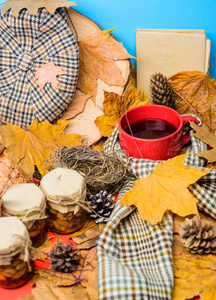 秋季饮料, 自制天然甜点。帽子围巾和蜂蜜天然糖果在罐子附近的杯茶背景覆盖的落叶。自然自制的秋季季节保持健康