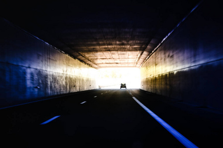 隧道尽头的汽车驶出隧道灯
