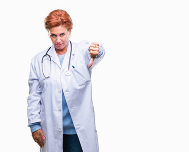 高级白种人医生女士穿着医疗制服，在孤立的背景下看起来不高兴和愤怒，表现出拒绝和消极的拇指向下的手势。 不好的表情。