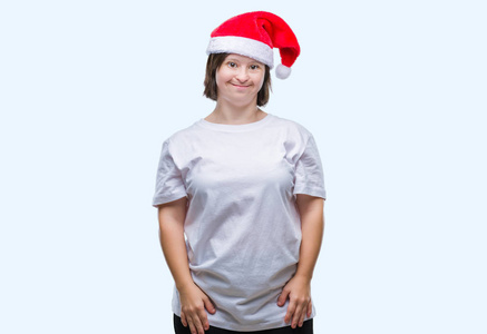 患有唐氏综合症的年轻成年女性戴着圣诞帽，在孤立的背景下，脸上带着快乐和凉爽的微笑。很幸运的人。