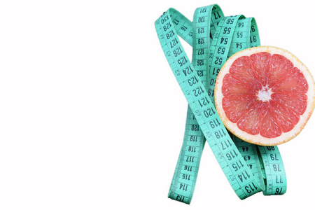 白色背景下的葡萄柚和减肥胶带是减肥和减肥的象征
