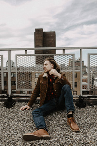 留胡子的嬉皮士坐在纽约曼哈顿美国的屋顶上。