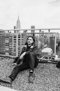 留胡子的嬉皮士坐在纽约曼哈顿美国的屋顶上。 黑白照片