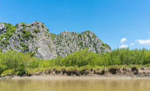 石头或岩石山或小山，有绿色的树，蓝天，水和云，在泰国的KhaoDang运河Khiri Khan泰国。 风景或风景夏季概念船游